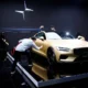 People polishing a luxury car at an event.